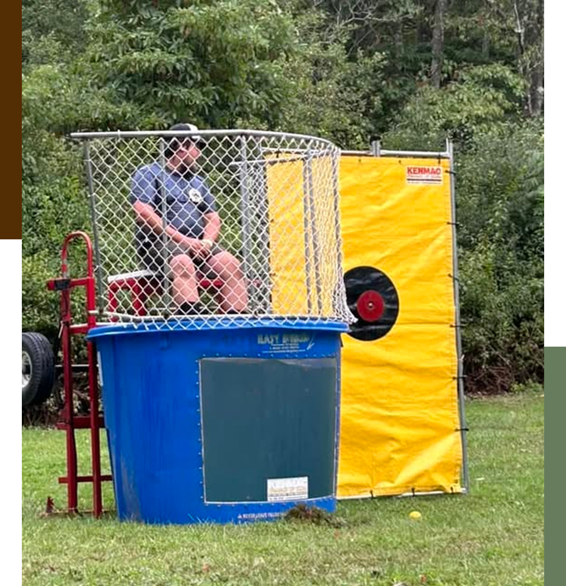 Man sitting in dunk tank at event.