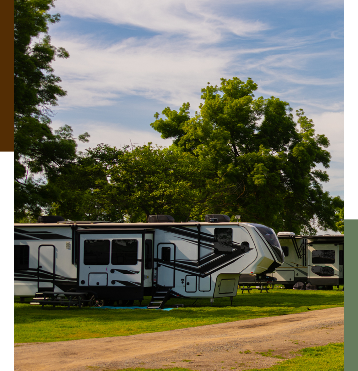 RV parked on grassy area under trees.
